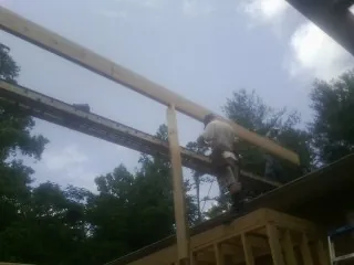 Carpenter setting a ridge beam over a new addition frame — Ice Dam Removal by Roofing Brothers in Barnegat Light