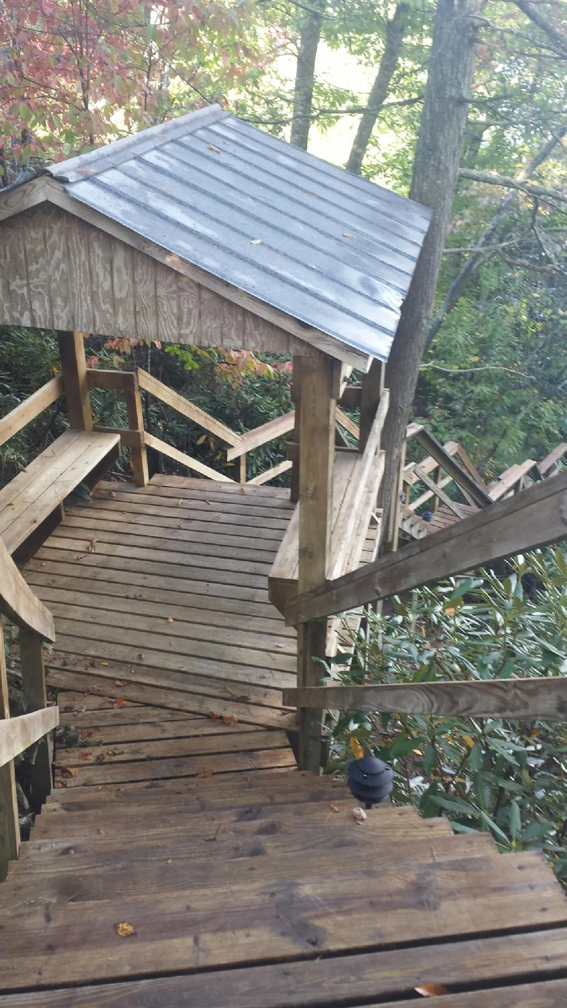 Metal roofed shelter over wooden steps on a wooded walkway — Skylight Repair & Installation work by our crew in Barnegat Light